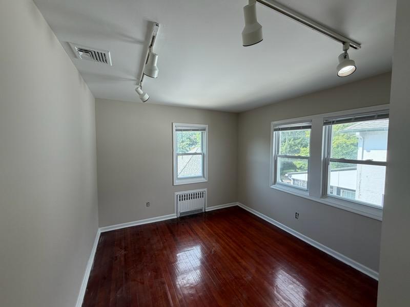 The same bedroom finished in warm greige with white window trim and baseboards